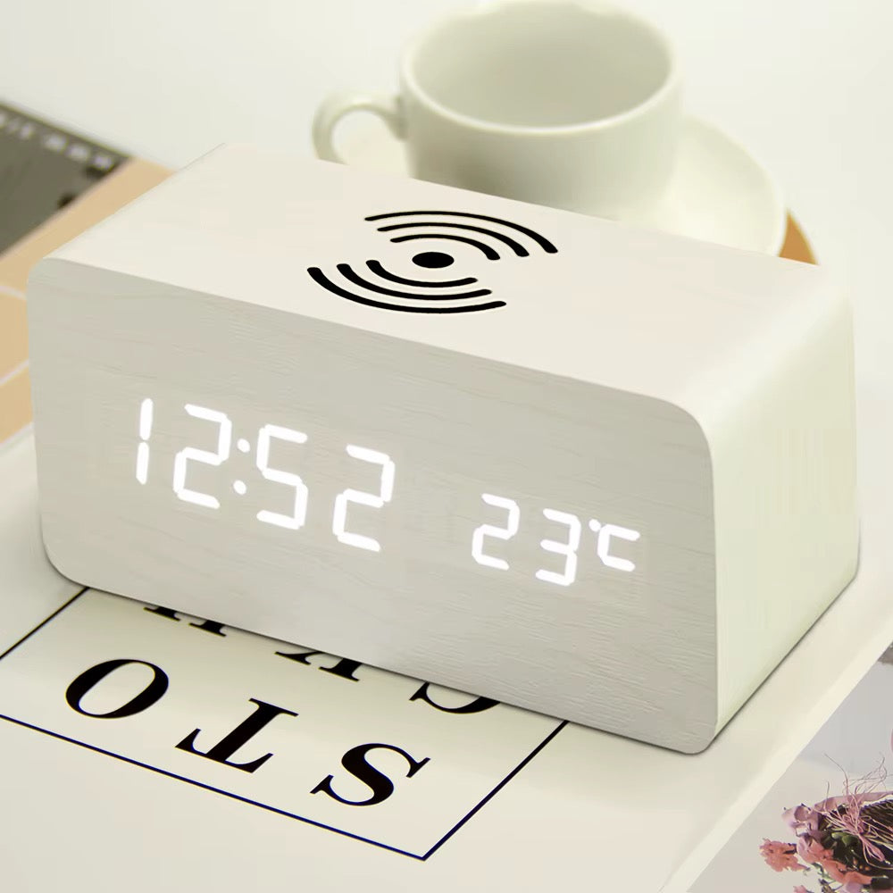 A wooden LED digital desk alarm clocks featuring Qi wireless charging pads built into their top surfaces