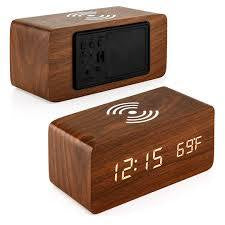 A wooden LED digital desk alarm clocks featuring Qi wireless charging pads built into their top surfaces