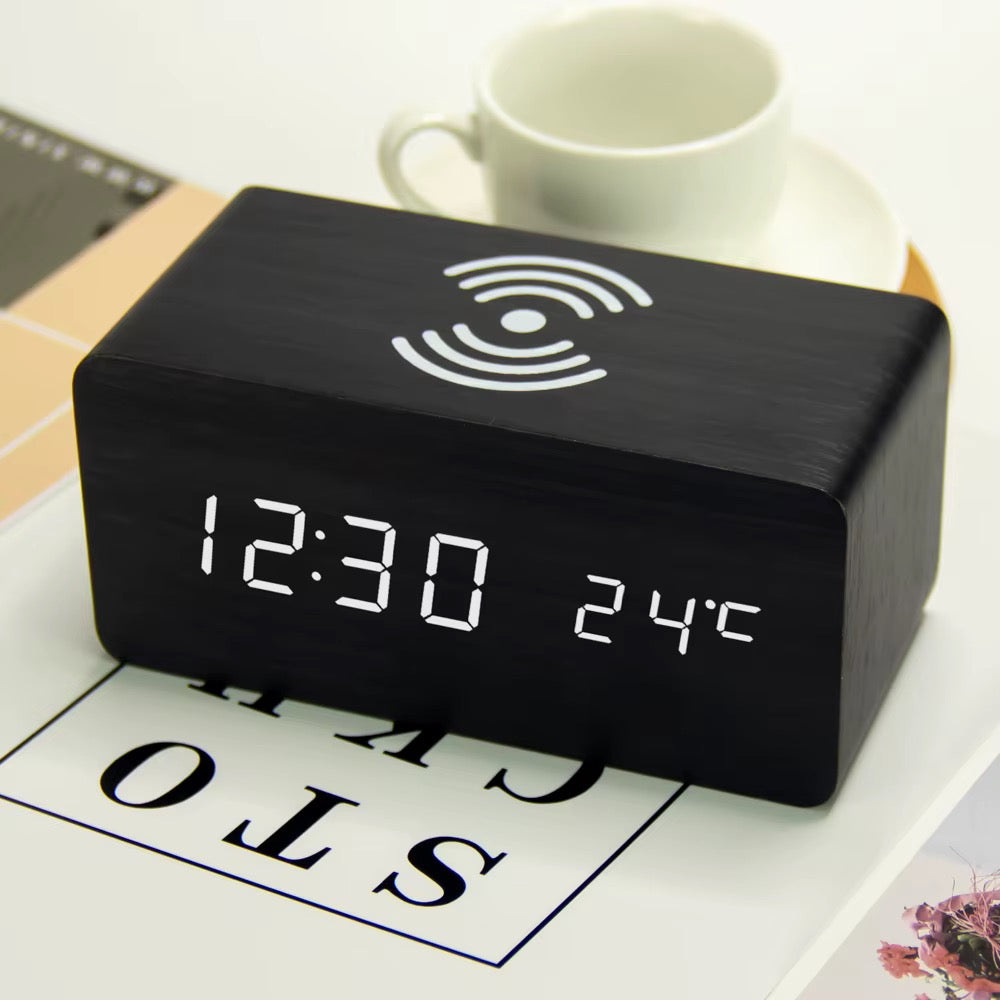 A wooden LED digital desk alarm clocks featuring Qi wireless charging pads built into their top surfaces